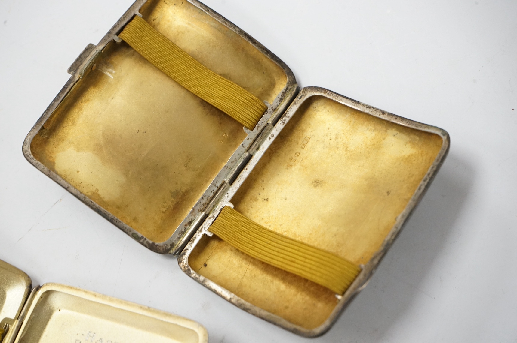 Three assorted George V silver cigarette cases and a silver matchbook case. Condition - fair